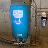 blue filter water pressure tank installed in basement